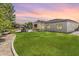 Expansive backyard with lush green grass, a covered patio with sitting areas and a built in barbecue near the swimming pool at 3410 E Inglewood Cir, Mesa, AZ 85213
