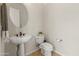 Half bathroom with a pedestal sink, toilet, and round mirror at 3410 E Inglewood Cir, Mesa, AZ 85213
