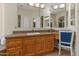 Bathroom with double sinks, granite countertops and vanity area with chair and mirror at 3410 E Inglewood Cir, Mesa, AZ 85213