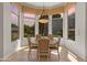 Cozy dining nook with bay windows offering outdoor views and a charming chandelier at 3410 E Inglewood Cir, Mesa, AZ 85213