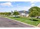 A beautifully landscaped home with solar panels, lush lawn, and manicured trees along a quiet street at 3410 E Inglewood Cir, Mesa, AZ 85213