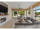 Sunlit living room with fireplace, backyard views through large windows, and a comfortable sectional at 3410 E Inglewood Cir, Mesa, AZ 85213