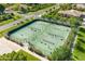 Aerial view of well-maintained tennis courts with players in a verdant community setting at 3410 E Inglewood Cir, Mesa, AZ 85213