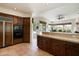 Open kitchen featuring custom wood cabinetry, tile countertops and floors, plus stainless steel appliances at 34221 N Boulders Pkwy, Scottsdale, AZ 85266