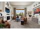 Bright living room with large windows overlooking pool, with fireplace, and neutral carpet and paint at 34221 N Boulders Pkwy, Scottsdale, AZ 85266