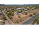Expansive property featuring a home with solar panels, surrounded by desert landscape, outbuildings, and distant mountain views at 37414 N 17Th Ave, Phoenix, AZ 85086