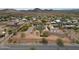 Wide aerial shot showcasing a desert home with solar panels, a long driveway, and surrounding desert landscape at 37414 N 17Th Ave, Phoenix, AZ 85086