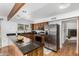 Spacious kitchen featuring wood cabinets, granite countertops, stainless steel appliances, and wood beam accent at 37414 N 17Th Ave, Phoenix, AZ 85086