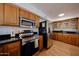 Kitchen features stainless appliances, skylight, granite counters, and wood cabinets at 37414 N 17Th Ave, Phoenix, AZ 85086