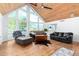 Sunlit living room with hardwood floors, beamed ceilings, and large triangular windows at 37414 N 17Th Ave, Phoenix, AZ 85086