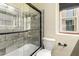 Modern bathroom featuring a gray tiled shower, bathtub, glass door, and toilet at 387 N 2Nd Ave # F2, Phoenix, AZ 85003