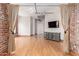 Cozy living room featuring hardwood floors, exposed brick, a modern entertainment center, and track lighting at 387 N 2Nd Ave # F2, Phoenix, AZ 85003