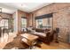 Cozy living room featuring exposed brick walls, hardwood floors, and a leather sofa at 387 N 2Nd Ave # F2, Phoenix, AZ 85003