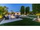 Inviting backyard features a sparkling pool, fire pit, lush landscaping, and covered outdoor kitchen at 4281 S Iowa St, Chandler, AZ 85248