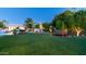Expansive backyard at night featuring a fireplace, lounge area, outdoor kitchen, and lush landscaping at 4281 S Iowa St, Chandler, AZ 85248