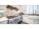 Charming kitchen features updated stainless appliances, custom white cabinetry, and stylish backsplash at 4281 S Iowa St, Chandler, AZ 85248