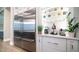 Modern kitchen with stainless steel refrigerator, custom cabinetry, and open shelving at 4281 S Iowa St, Chandler, AZ 85248