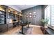 Home office with built-in shelving, wood-look accent wall, and an adjustable desk at 4281 S Iowa St, Chandler, AZ 85248