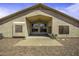 Home with expansive desert landscaping in the backyard and covered patio area with exterior lighting at 43283 W Hillman Dr, Maricopa, AZ 85138
