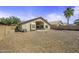 View of home's backyard, enclosed by fencing, features desert landscaping with crushed rock and a covered patio at 43283 W Hillman Dr, Maricopa, AZ 85138