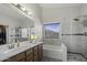 Neutral bathroom features a double vanity, soaking tub, glass shower, and natural light at 43283 W Hillman Dr, Maricopa, AZ 85138