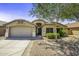 Charming single-story home featuring a manicured front yard with desert landscaping and a two-car garage at 43283 W Hillman Dr, Maricopa, AZ 85138
