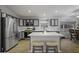Modern kitchen featuring updated cabinets, stainless appliances, an island with bar stools and a window with a view to the yard at 43283 W Hillman Dr, Maricopa, AZ 85138