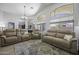 Spacious living room boasts cathedral ceilings, comfortable seating, natural light and updated flooring at 43283 W Hillman Dr, Maricopa, AZ 85138