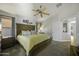 A view of the main bedroom featuring a large bed, plenty of natural light and an ensuite at 43283 W Hillman Dr, Maricopa, AZ 85138