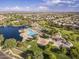 Scenic aerial view of the community with a lake, pool, playground, and well-maintained landscaping at 43344 W Oster Dr, Maricopa, AZ 85138