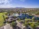 Aerial view of the community featuring a lake, pool, clubhouse, and mountain views in the distance at 43344 W Oster Dr, Maricopa, AZ 85138