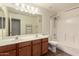 Bathroom featuring dual vanity, cherry cabinets, and shower-tub combo at 43344 W Oster Dr, Maricopa, AZ 85138
