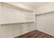 Walk-in closet with hardwood floor, white walls and shelving, and wooden rails at 43344 W Oster Dr, Maricopa, AZ 85138