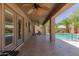 Covered patio area with ceiling fans, columns, and access to a pool at 43344 W Oster Dr, Maricopa, AZ 85138