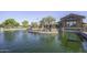 Scenic pond with a central gazebo, fountain, and charming community buildings in the background at 43344 W Oster Dr, Maricopa, AZ 85138