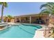 Sparkling pool and spa area with palm trees, outdoor furniture, and privacy fencing at 43344 W Oster Dr, Maricopa, AZ 85138