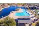 Resort-style pool area with a lake view, cabana, palm trees, and meticulously kept landscaping at 43344 W Oster Dr, Maricopa, AZ 85138