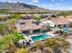 Charming aerial view of backyard with pool, spa, outdoor kitchen and artificial turf at 5033 N 205Th Gln, Buckeye, AZ 85396