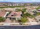 Stunning aerial view of a Southwestern home near a golf course, showcasing its tile roof and desert landscaping at 5033 N 205Th Gln, Buckeye, AZ 85396