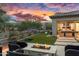 Inviting backyard with a cozy fire pit and scenic mountain views at sunset at 5033 N 205Th Gln, Buckeye, AZ 85396