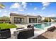 Luxurious backyard with a sparkling pool, travertine tile, a fire pit, and outdoor seating at 5033 N 205Th Gln, Buckeye, AZ 85396