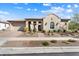 Stunning Southwestern-style home with a desert landscape, decorative arches, and a brick-paved driveway and walkway at 5033 N 205Th Gln, Buckeye, AZ 85396