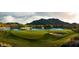 Lush golf course with pristine green, tranquil lake, and scenic mountain backdrop at 5033 N 205Th Gln, Buckeye, AZ 85396
