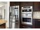 Kitchen with stainless steel refrigerator and built-in oven/microwave combination at 5033 N 205Th Gln, Buckeye, AZ 85396