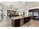 Gourmet kitchen featuring a large island with granite countertops, stainless steel appliances, and dark wood cabinets at 5033 N 205Th Gln, Buckeye, AZ 85396