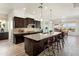 Spacious kitchen with dark wood cabinets, granite countertops, large island, and stainless steel appliances at 5033 N 205Th Gln, Buckeye, AZ 85396