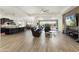 Spacious living room with wood-look tile, an open floor plan, and access to an outdoor patio and pool area at 5033 N 205Th Gln, Buckeye, AZ 85396