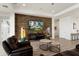 A spacious living room showcasing an eye-catching stone accent wall and contemporary decor at 5033 N 205Th Gln, Buckeye, AZ 85396