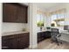 Home office featuring built-in desk, wood floors, granite counters, and plenty of natural light at 5033 N 205Th Gln, Buckeye, AZ 85396