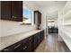 Kitchen with a view to the pantry, showcasing open shelving, ample counter space, and natural light at 5033 N 205Th Gln, Buckeye, AZ 85396